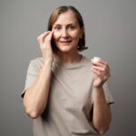 A woman applying retinol on her face