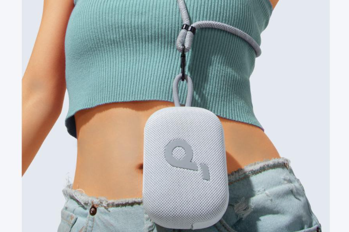 Woman wearing a small speaker on a lanyard